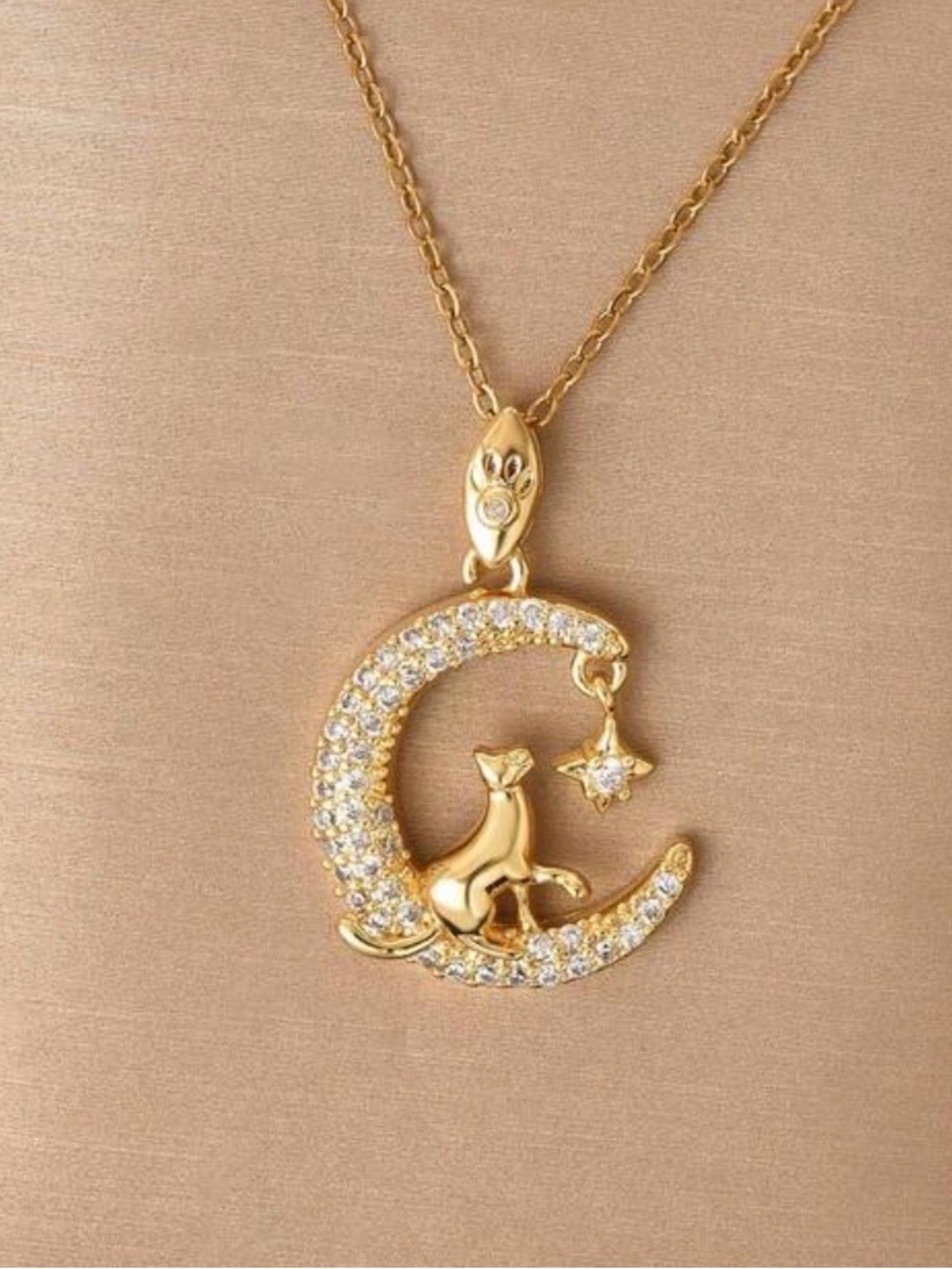 Cat on moon batting at star necklace